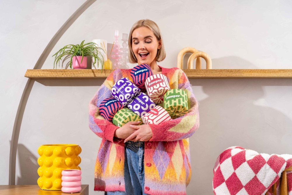 Model holding colourful packs of bamboo toilet paper